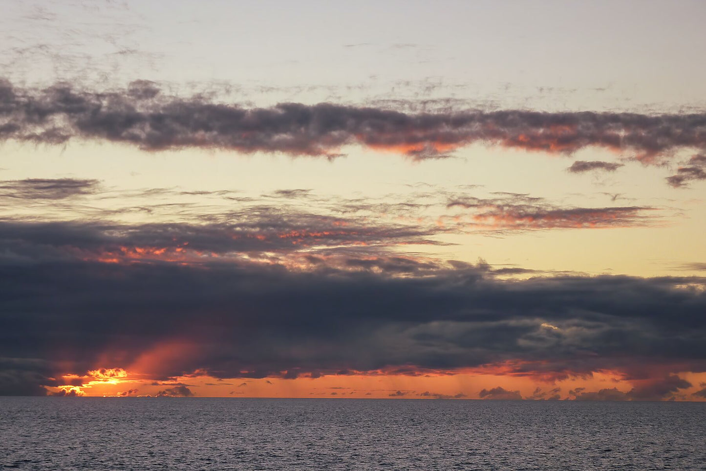 Le soleil disparaît dans l'océan par temps nuageux