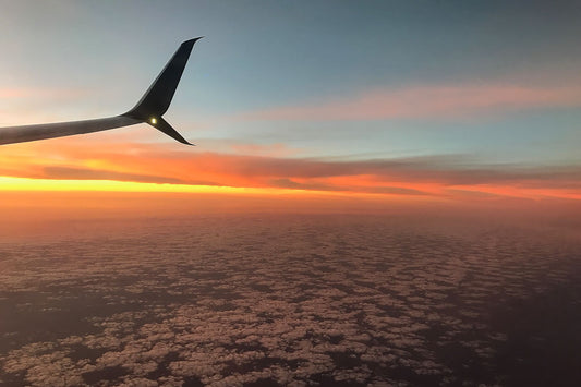 Flying over the clouds at sunset
